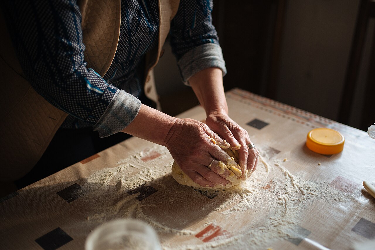 Hands kneading bread dough in the bakery